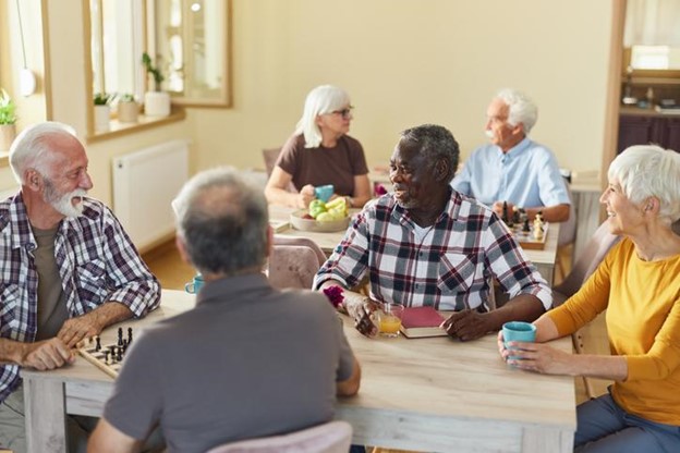 A group of happy seniors having a conversation around a table